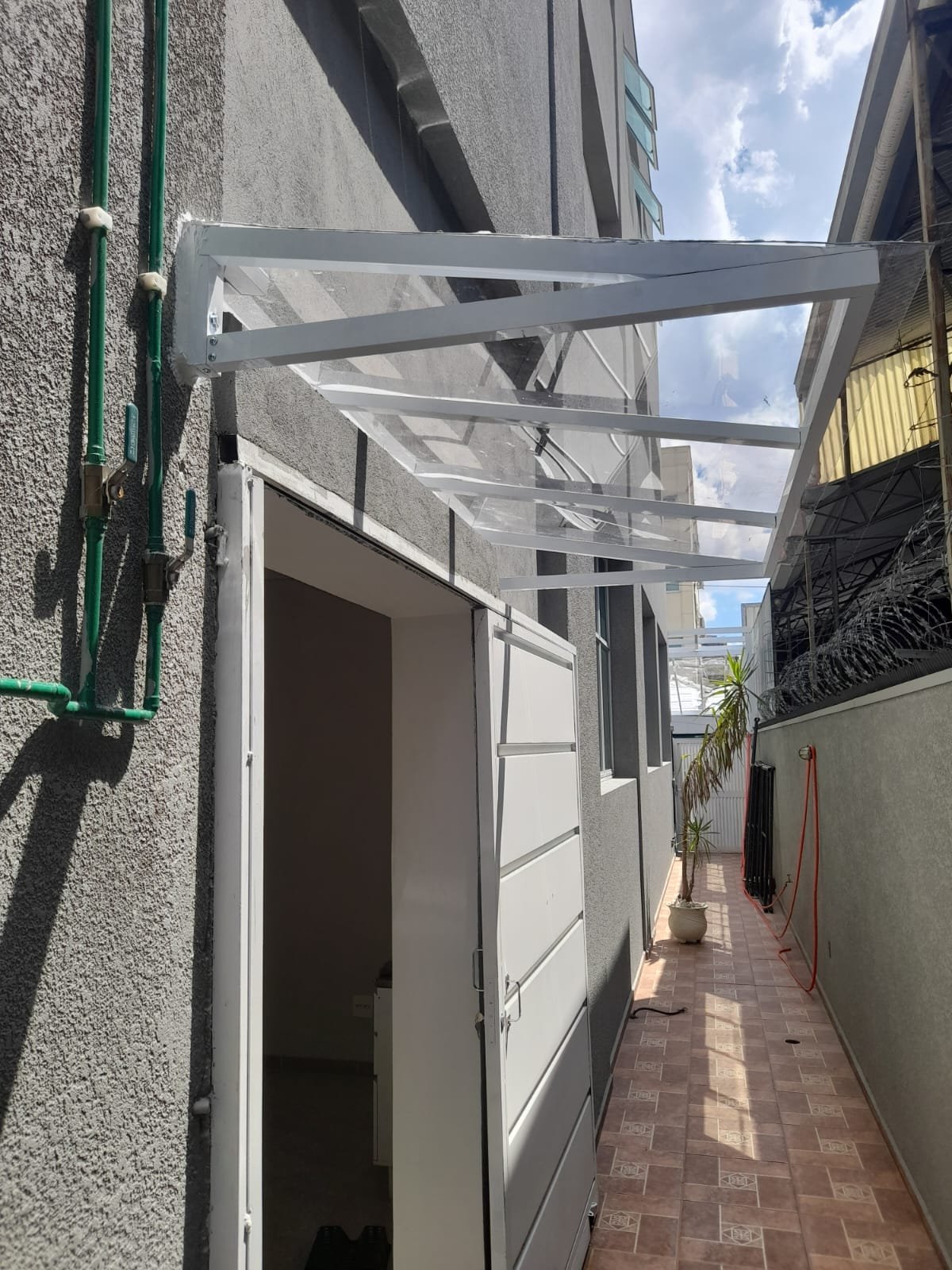 Toldo e cobertura instalada em área externa, oferecendo proteção contra sol e chuva com estrutura resistente e acabamento profissional. - 