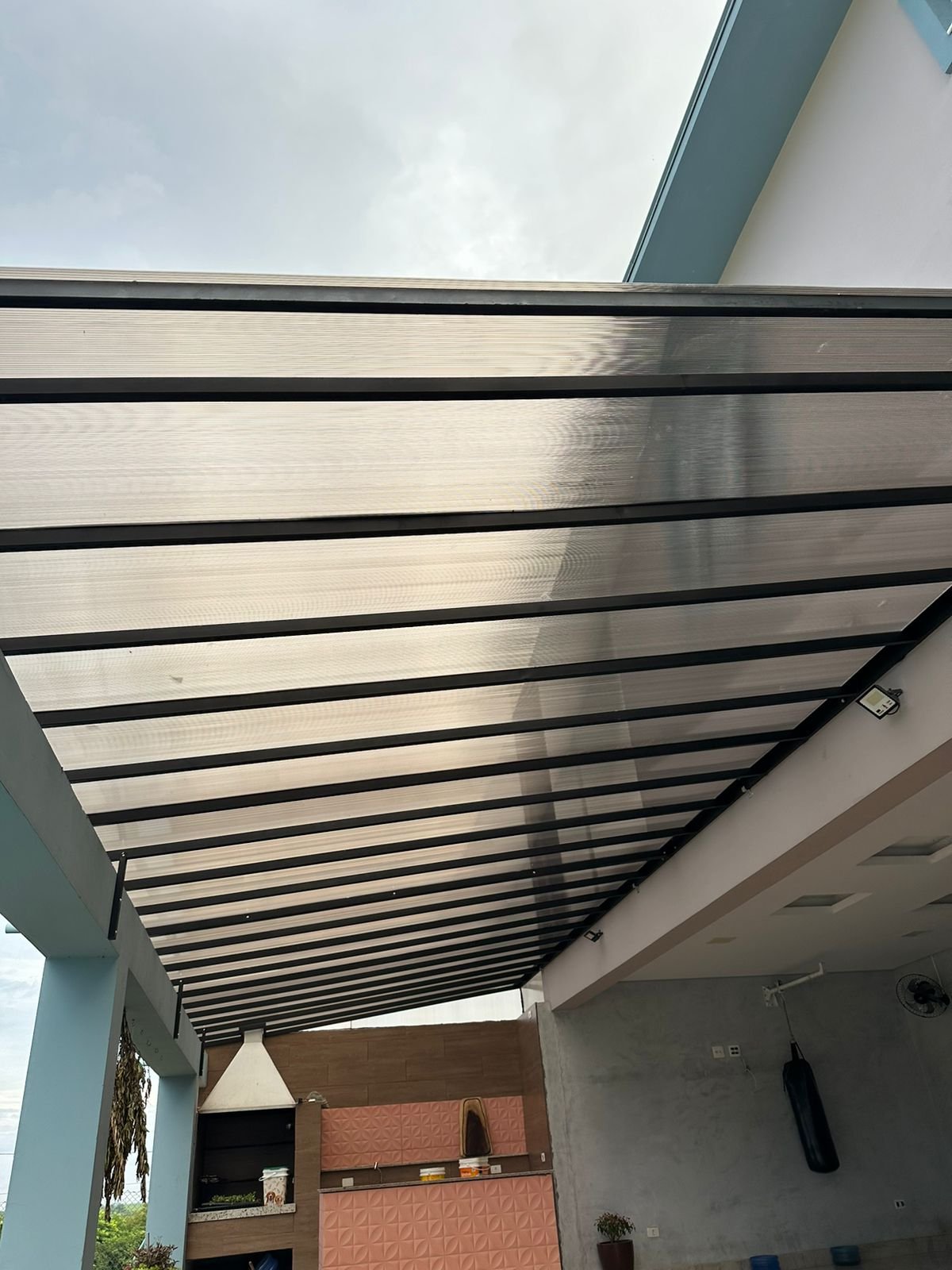 Toldo e cobertura instalada em área externa, oferecendo proteção contra sol e chuva com estrutura resistente e acabamento profissional. - 